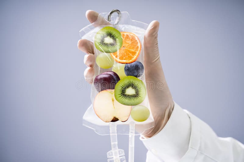 Male Doctor Holding Saline Bag With Fruit Slices Inside In Hospital. Male Doctor Holding Saline Bag With Fruit Slices Inside In Hospital