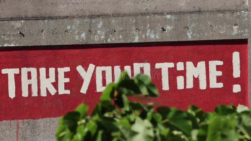 γκράφιτι με παρότρυνση αφιερώστε το χρόνο σας στον κόκκινο τοίχο απόθεμα βίντεο