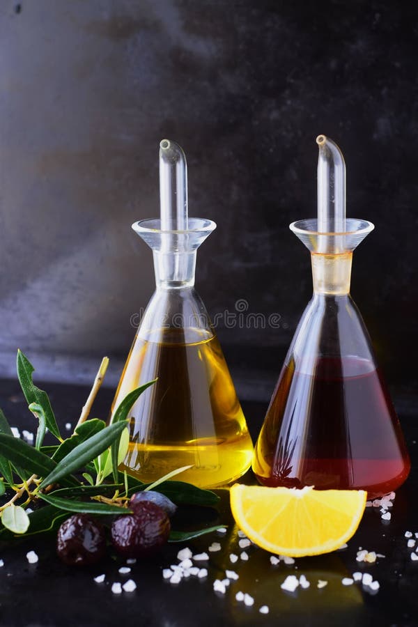 Γκρίζο αφηρημένο υπόβαθρο με τα βάζα γυαλιού ελαιολάδου και ξιδιού κρασιού με το λεμόνι, το άλας θάλασσας, το σκόρδο και το κλαδί στοκ εικόνα με δικαίωμα ελεύθερης χρήσης Γκρίζο αφηρημένο υπόβαθρο με τα βάζα γυαλιού ελαιολάδου και ξιδιού κρασιού με το λεμόνι, το άλας θάλασσας, το σκόρδο και το κλαδί στοκ εικόνα με δικαίωμα ελεύθερης χρήσης
