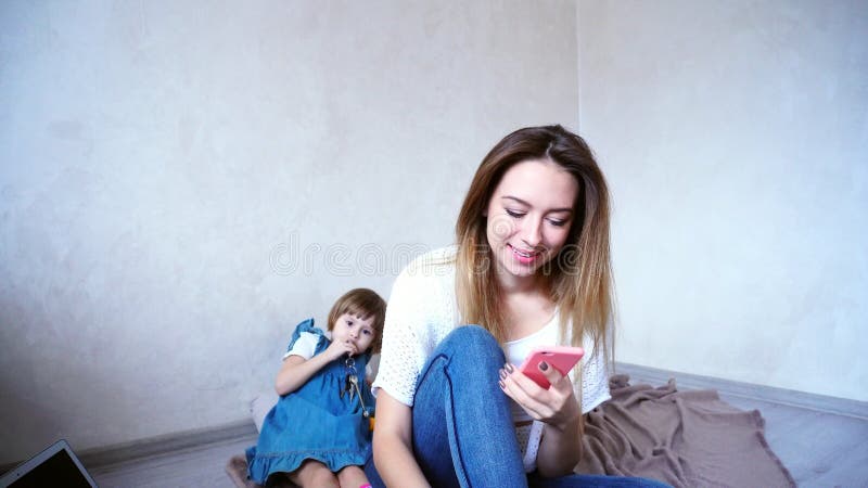 Γοητεία της θηλυκής και νέας μητέρας που μιλά στο τηλέφωνο στο υπόβαθρο στοκ φωτογραφία με δικαίωμα ελεύθερης χρήσης Γοητεία της θηλυκής και νέας μητέρας που μιλά στο τηλέφωνο στο υπόβαθρο στοκ φωτογραφία με δικαίωμα ελεύθερης χρήσης