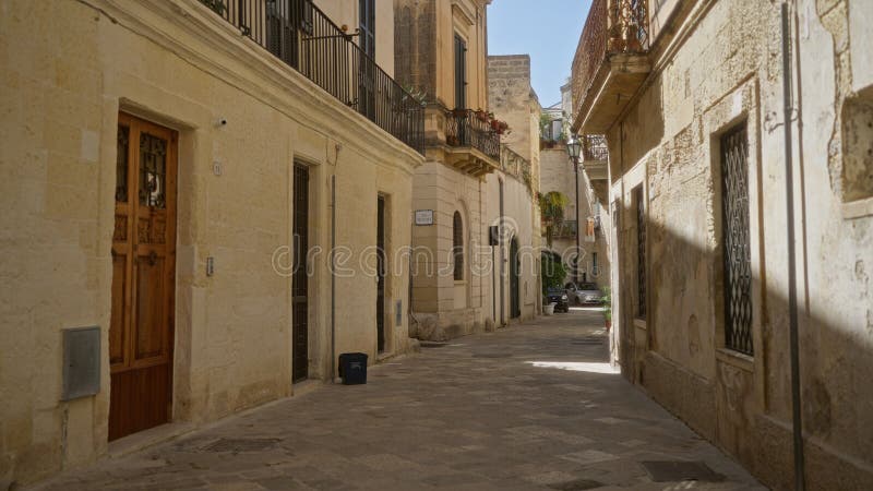 Γοητευτικός στενός δρόμος στην Lecce puglia ιταλία που παρουσιάζει αρχαία πέτρινα κτίρια με μπαλκόνια και μια γαλήνια ευρωπαϊκή πό στοκ εικόνες με δικαίωμα ελεύθερης χρήσης