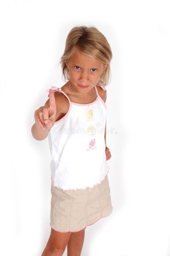 Little girl stands with her one index finger pointing in the air. Indicating the number 1, to stop, hold on or slow down. Little girl stands with her one index finger pointing in the air. Indicating the number 1, to stop, hold on or slow down.