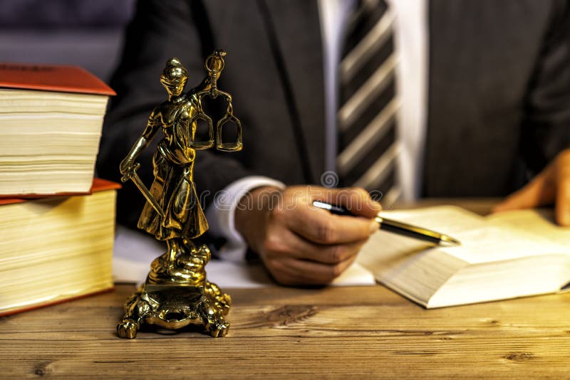 γραφείο δικηγόρου με άγαλμα της Δικαιοσύνης, της θεάς Ιουστίτια, στο γραφείο στοκ εικόνες