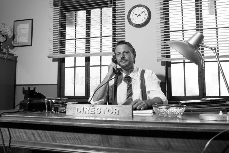 1950s style office: director smiling and talking on the phone. 1950s style office: director smiling and talking on the phone.