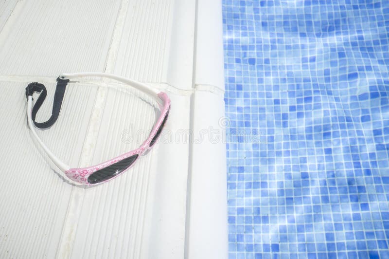 Γυαλιά ηλίου μικρών κοριτσιών πέρα από το poolside κολύμβησης στοκ φωτογραφία με δικαίωμα ελεύθερης χρήσης