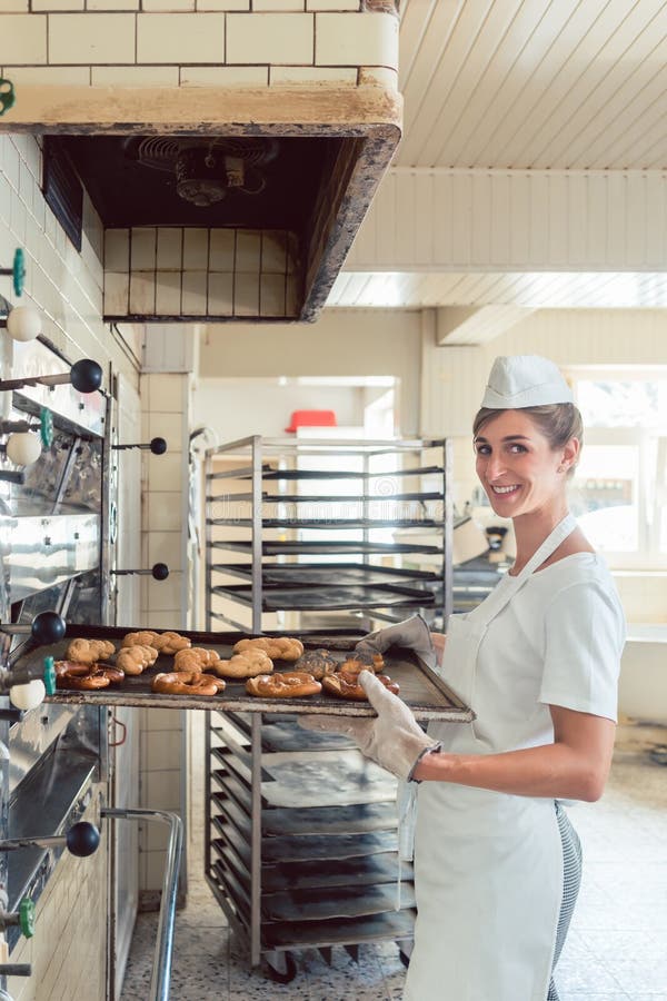Γυναίκα Baker που παίρνει τα προϊόντα αρτοποιίας από το φούρνο στοκ φωτογραφία με δικαίωμα ελεύθερης χρήσης