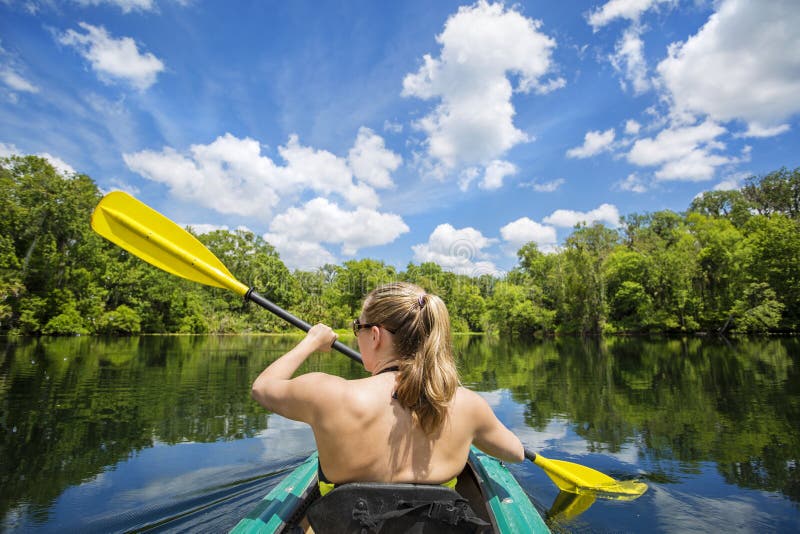 Γυναίκα Kayaking κάτω από έναν όμορφο τροπικό ποταμό ζουγκλών στοκ φωτογραφίες