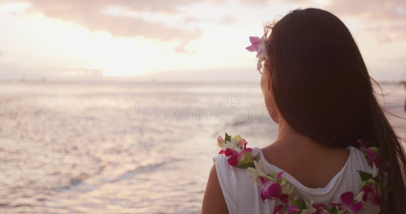 γυναίκα από τη χαβάη που φοράει ένα κολιέ από λουλούδι στην παραλία ηλιοβασίλεμα για το πάρτι της λουάου στη χαβάη