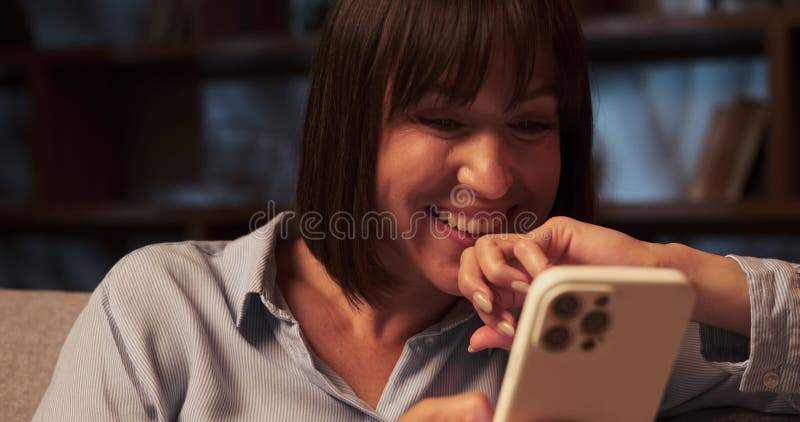γυναίκα από τον καύκασο γελάει ενώ χρησιμοποιεί το τηλέφωνο