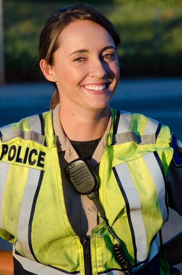 A female police officer smiles during her shift. A female police officer smiles during her shift.