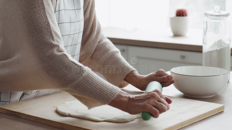 γυναίκα ισοπεδώνει τη ζύμη με το rolingpin κοντινή πλαγιά φιλμ μικρού μήκους