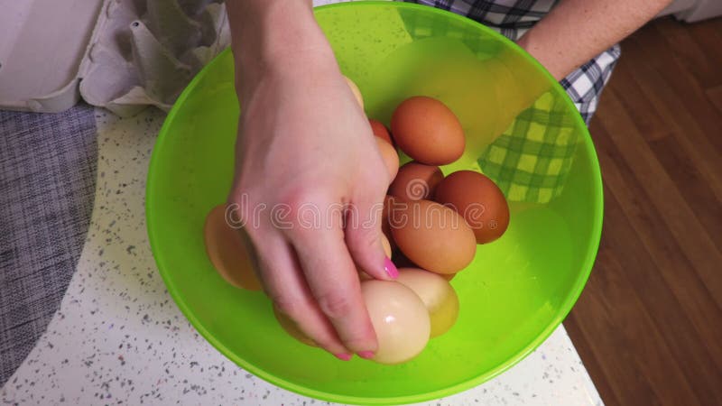 Γυναίκα με τα αυγά κοτόπουλου πράσινο στενό σε επάνω κύπελλων