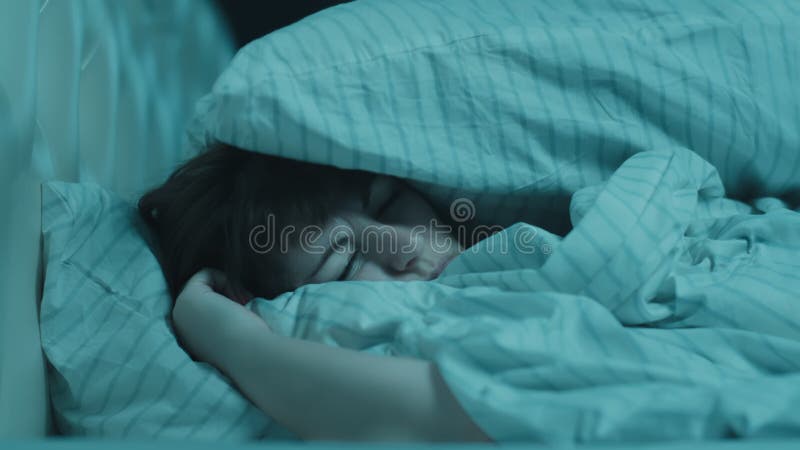 γυναίκα μελαχρινή διαταραγμένη από τον δυνατό θόρυβο δυσκολία στον ύπνο σκεπάζοντας αυτιά με μαξιλάρι που αισθάνεται αγχωμένη. προ απόθεμα βίντεο