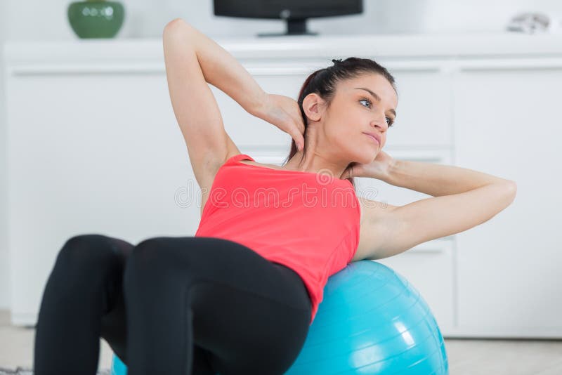 Γυναίκα που ασκεί τα ABS στη σφαίρα pilates στοκ εικόνα Γυναίκα που ασκεί τα ABS στη σφαίρα pilates στοκ εικόνα