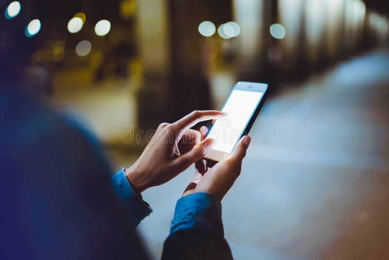 Γυναίκα που δείχνει το δάχτυλο στο κενό smartphone οθόνης στο φως υποβάθρου bokeh στην ατμοσφαιρική πόλη νύχτας, hipster blogger στοκ φωτογραφία Γυναίκα που δείχνει το δάχτυλο στο κενό smartphone οθόνης στο φως υποβάθρου bokeh στην ατμοσφαιρική πόλη νύχτας, hipster blogger στοκ φωτογραφία