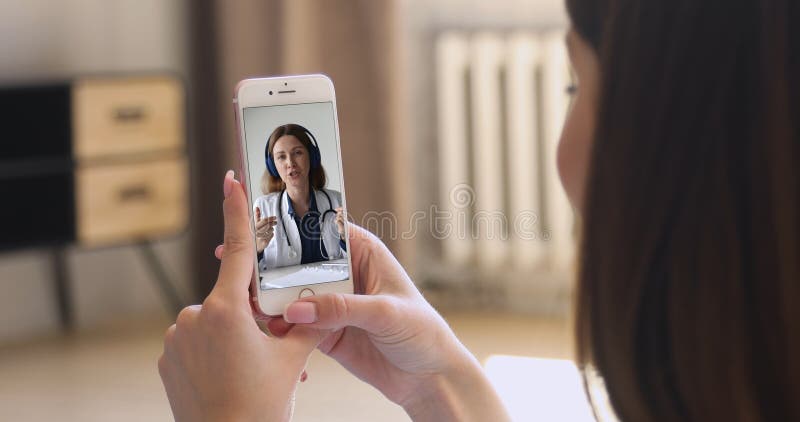 Γυναίκα που κρατά smartphone με συμμετοχή σε βιντεοκλήση με επαγγελματία ιατρό στοκ εικόνες