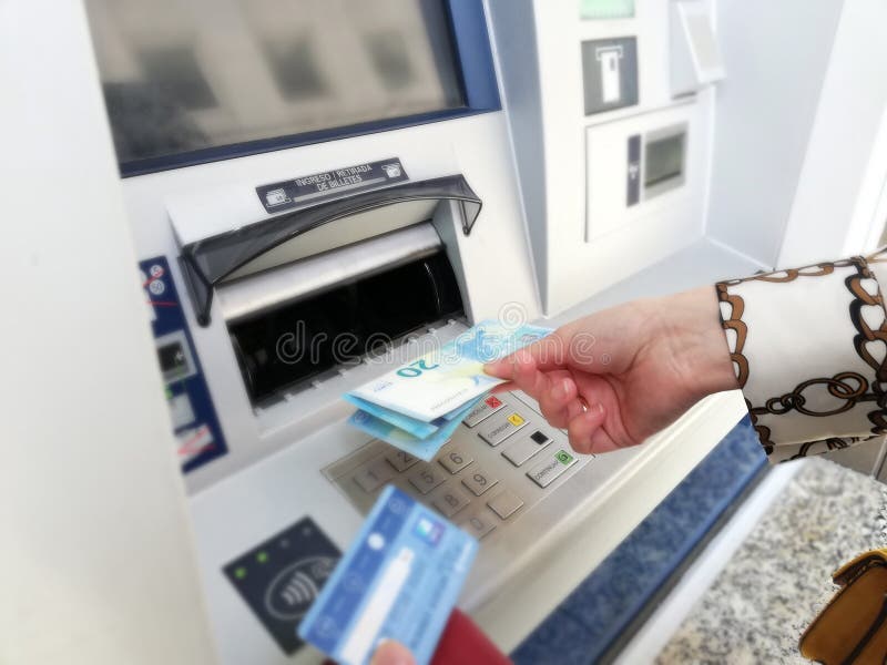 Γυναίκα που παίρνει τα χρήματα από το ATM στοκ εικόνα Γυναίκα που παίρνει τα χρήματα από το ATM στοκ εικόνα