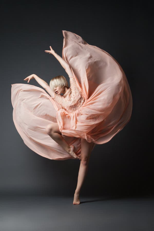 Woman in light chiffon dress dancing sensually on black plain background. Woman in light chiffon dress dancing sensually on black plain background.