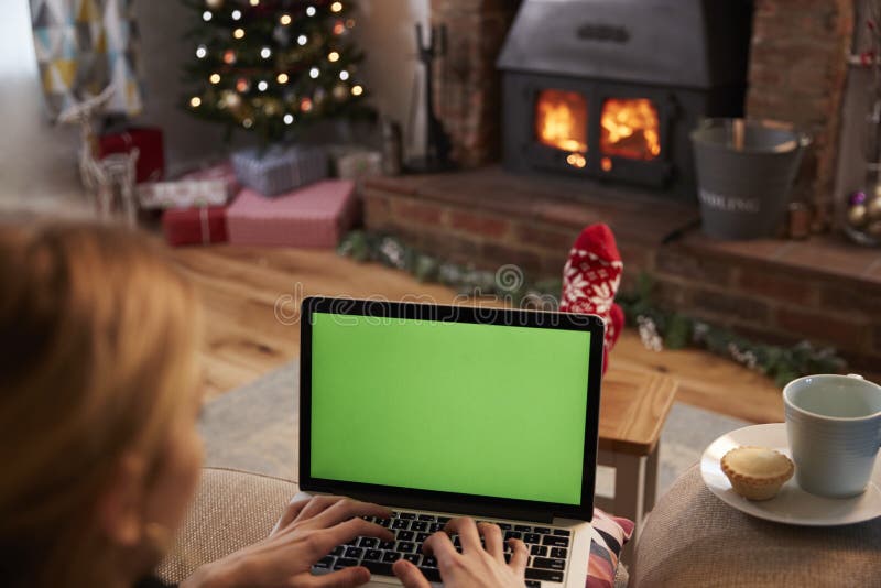 Γυναίκα που χρησιμοποιεί το lap-top στο δωμάτιο που διακοσμείται για τα Χριστούγεννα στοκ εικόνες με δικαίωμα ελεύθερης χρήσης Γυναίκα που χρησιμοποιεί το lap-top στο δωμάτιο που διακοσμείται για τα Χριστούγεννα στοκ εικόνες με δικαίωμα ελεύθερης χρήσης