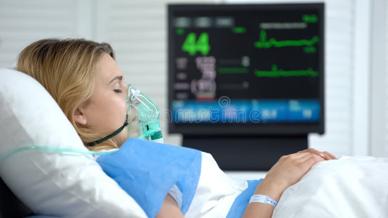 Γυναίκα σε κώμα, καρδιακός ρυθμός σε ηλεκτροκαρδιογραφική οθόνη, μονάδα νοσοκομείου εντατικής θεραπείας στοκ εικόνα Γυναίκα σε κώμα, καρδιακός ρυθμός σε ηλεκτροκαρδιογραφική οθόνη, μονάδα νοσοκομείου εντατικής θεραπείας στοκ εικόνα