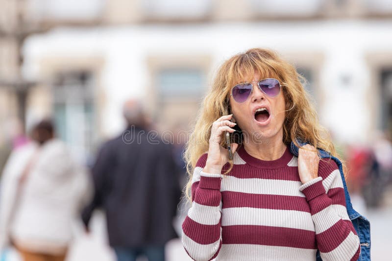 γυναίκα στο δρόμο κοιτάζει το κινητό ή το smartphone στοκ φωτογραφίες με δικαίωμα ελεύθερης χρήσης