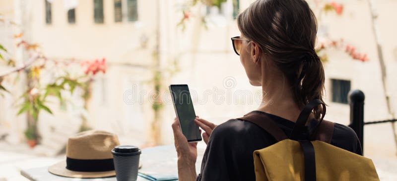 γυναίκα τουρίστρια που χρησιμοποιεί smartphone σε πανοραμικό πανό καφετέριας. κορίτσι ταξιδιώτης που κοιτάζει το κινητό τηλέφωνο. στοκ εικόνες