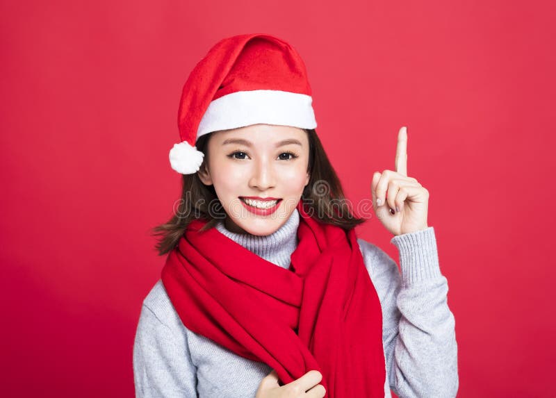 Γυναίκα Χριστουγέννων που φορά το καπέλο santa και που δείχνει επάνω στοκ φωτογραφία με δικαίωμα ελεύθερης χρήσης