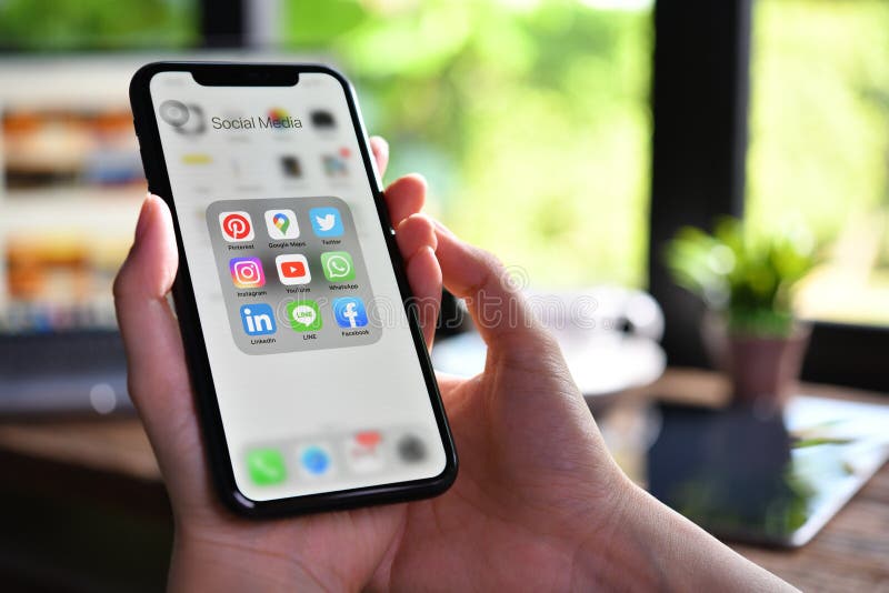 γυναικεία social phone social media που κρατά iphone xr με εικονίδια των μέσων κοινωνικής δικτύωσης στην οθόνη στην καφετέρια στοκ εικόνες