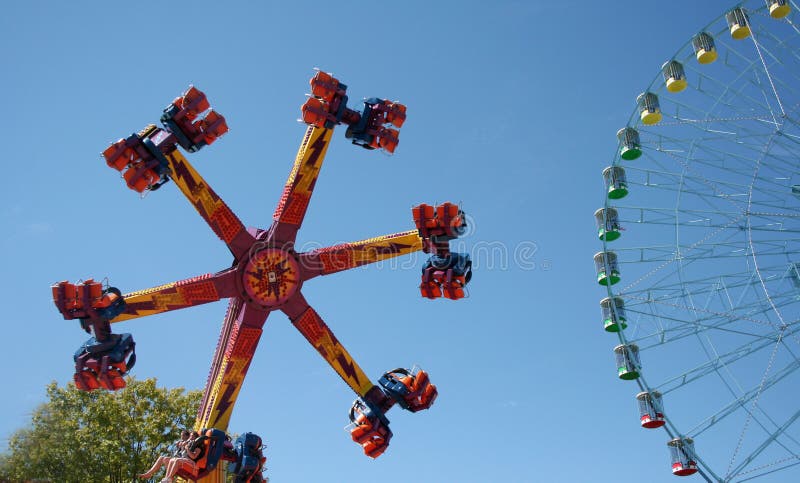 A carnival ride turns in circles against the blue sky. A carnival ride turns in circles against the blue sky.