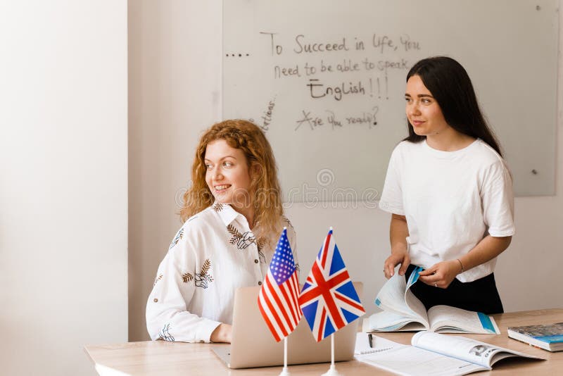 Teacher of english asks student in white class. 2 girls student answers to teacher. Working in group. Study english and british language. Teacher of english asks student in white class. 2 girls student answers to teacher. Working in group. Study english and british language.