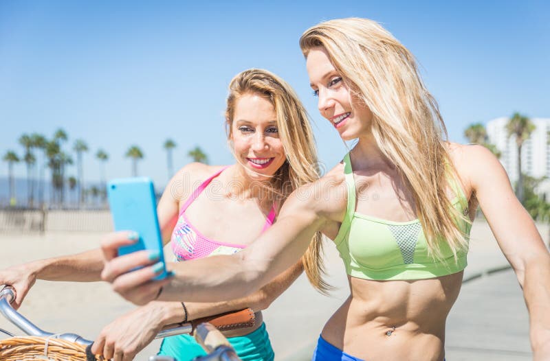 Δίδυμες αδελφές που παίρνουν selfie στο Λος Άντζελες στη διάβαση πεζών παραλιών στοκ εικόνα