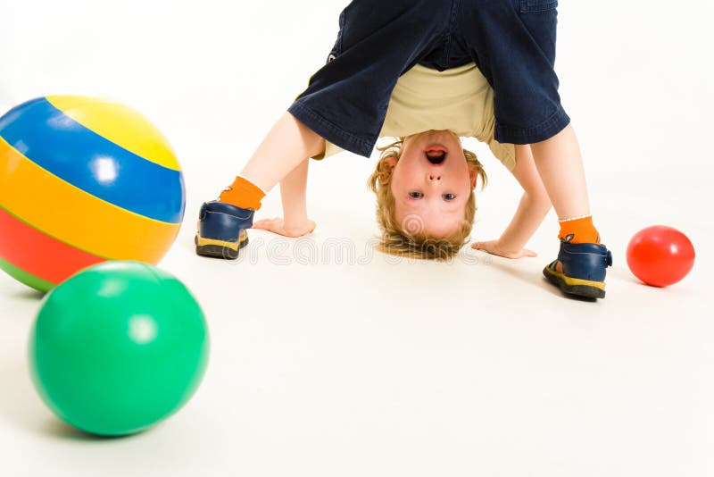 Portrait of boy looking at camera between his legs. Portrait of boy looking at camera between his legs