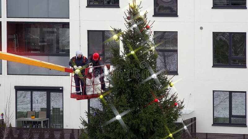 Δημοτικοί εργαζόμενοι στο γερανό που διακοσμούν το χριστουγεννιάτικο δέντρο Δραματική βαθμολόγηση χρώματος