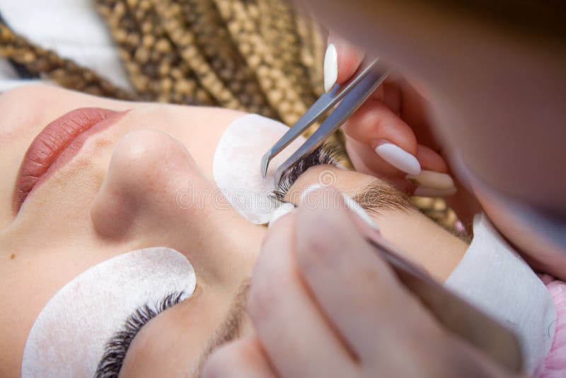 Διαδικασία επέκτασης Eyelash Μάτι γυναικών με μακρύ ψεύτικο Eyelashes Κλείστε επάνω το μακρο πυροβολισμό των τσιμπιδακιών στα χέρ στοκ φωτογραφία με δικαίωμα ελεύθερης χρήσης Διαδικασία επέκτασης Eyelash Μάτι γυναικών με μακρύ ψεύτικο Eyelashes Κλείστε επάνω το μακρο πυροβολισμό των τσιμπιδακιών στα χέρ στοκ φωτογραφία με δικαίωμα ελεύθερης χρήσης