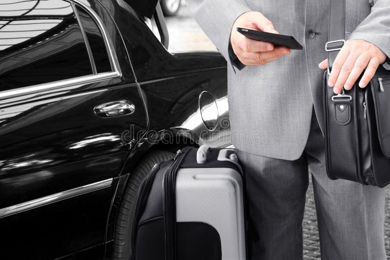 Traveling Businessman with His Luggage Using Phone. Traveling Businessman with His Luggage Using Phone