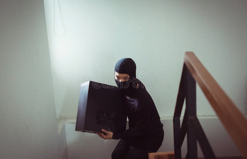 Διαρρήκτης ατόμων στο μαύρο stealing υπολογιστή ληστών μασκών από το σπίτι στοκ εικόνες με δικαίωμα ελεύθερης χρήσης Διαρρήκτης ατόμων στο μαύρο stealing υπολογιστή ληστών μασκών από το σπίτι στοκ εικόνες με δικαίωμα ελεύθερης χρήσης