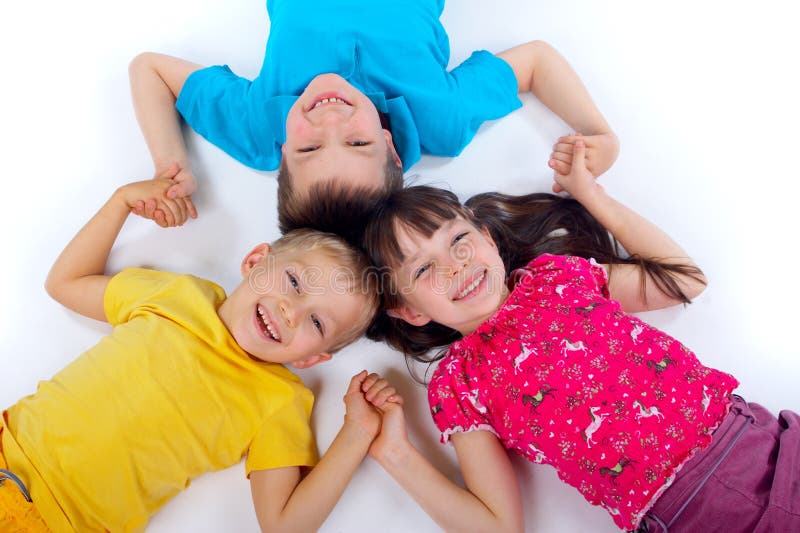 Children lying on backs and liking arms together, having fun. Children lying on backs and liking arms together, having fun