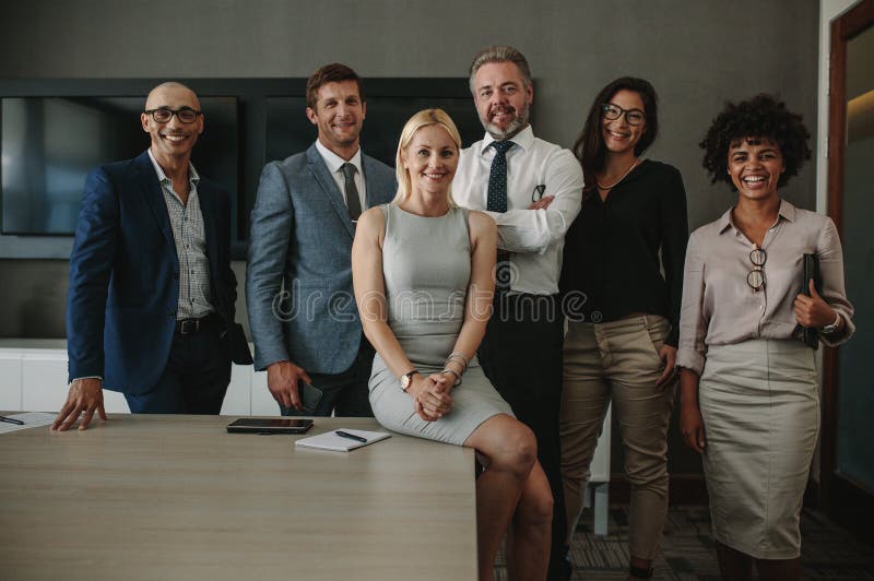 Portrait of diverse business professionals together in office meeting room. Team of corporate professionals looking at camera and smiling in board room. Portrait of diverse business professionals together in office meeting room. Team of corporate professionals looking at camera and smiling in board room.