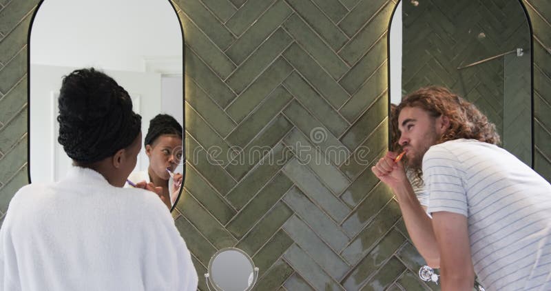 Διαφορετικό ζευγάρι : νεαρή Αφροαμερικανή γυναίκα και νεαρός Καυκάσιος σε ένα σύγχρονο μπάνιο απόθεμα βίντεο