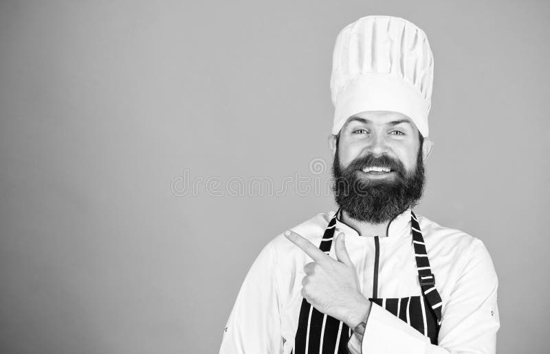 Δοκιμάστε κάτι ειδικό Βέβαιος γενειοφόρος ευτυχής άσπρος ομοιόμορφος αρχιμαγείρων Το μυστικό μου τοποθετεί αιχμή σε μαγειρικό Μαγ στοκ φωτογραφίες Δοκιμάστε κάτι ειδικό Βέβαιος γενειοφόρος ευτυχής άσπρος ομοιόμορφος αρχιμαγείρων Το μυστικό μου τοποθετεί αιχμή σε μαγειρικό Μαγ στοκ φωτογραφίες