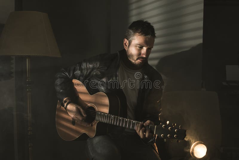 Δραματικό πορτρέτο ενός ατόμου που παίζει μια κιθάρα guitarist
