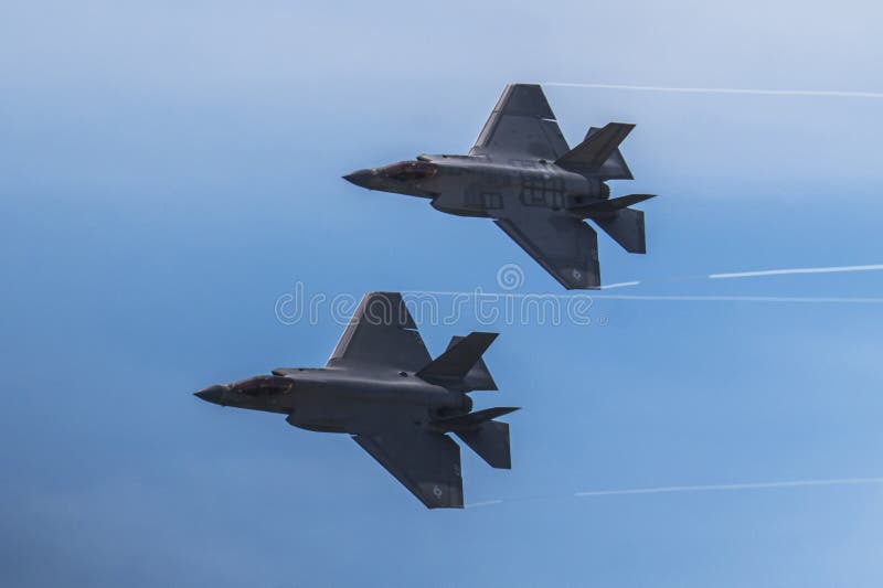 δύο f35 μαχητικό jet με κεραυνό πετώντας πάνω σε γαλάζιο ουρανό σε σχηματισμό στοκ εικόνες