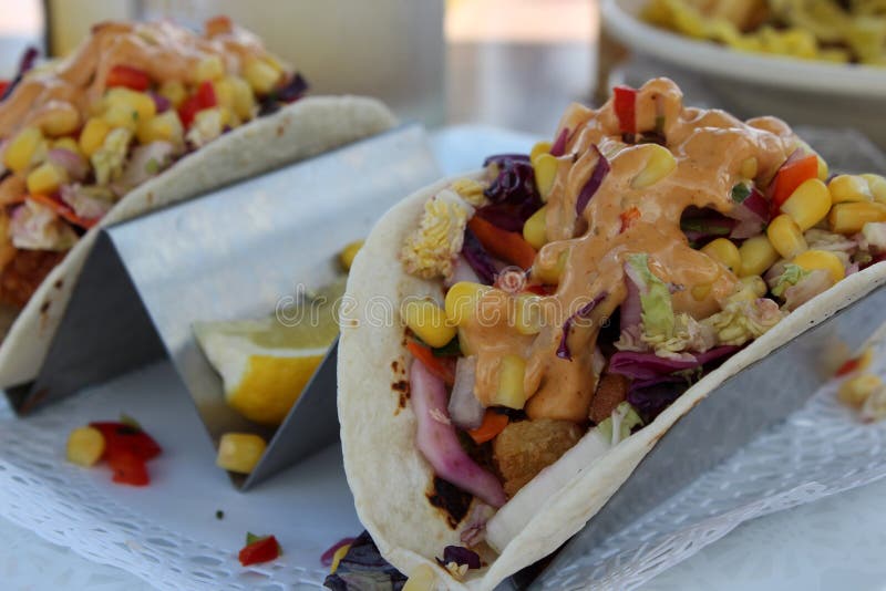 Δύο flavorful tacos ψαριών μαλακά tortillas που καλύπτονται με τα λαχανικά και τον επίδεσμο στοκ φωτογραφία Δύο flavorful tacos ψαριών μαλακά tortillas που καλύπτονται με τα λαχανικά και τον επίδεσμο στοκ φωτογραφία