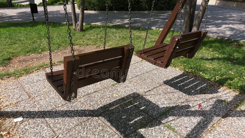 δύο άδειες ξύλινες κούνιες σε πάρκο φιλμ μικρού μήκους