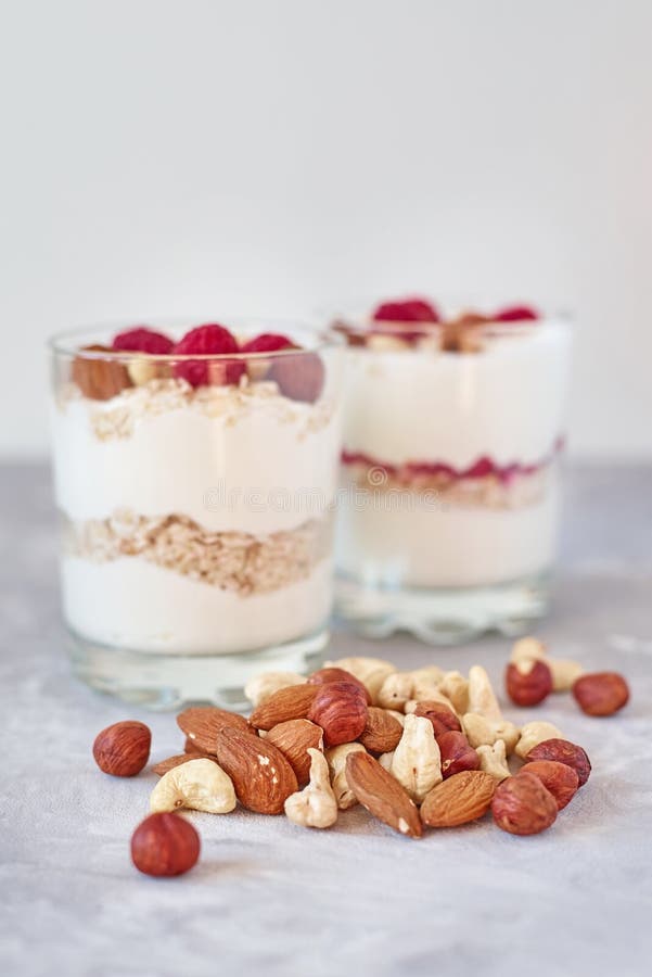 Δύο γυαλιά του ελληνικού granola γιαουρτιού με τα σμέουρα, oatmeal τις νιφάδες και τα καρύδια σε ένα άσπρο υπόβαθρο Υγιής διατροφ στοκ εικόνες με δικαίωμα ελεύθερης χρήσης Δύο γυαλιά του ελληνικού granola γιαουρτιού με τα σμέουρα, oatmeal τις νιφάδες και τα καρύδια σε ένα άσπρο υπόβαθρο Υγιής διατροφ στοκ εικόνες με δικαίωμα ελεύθερης χρήσης