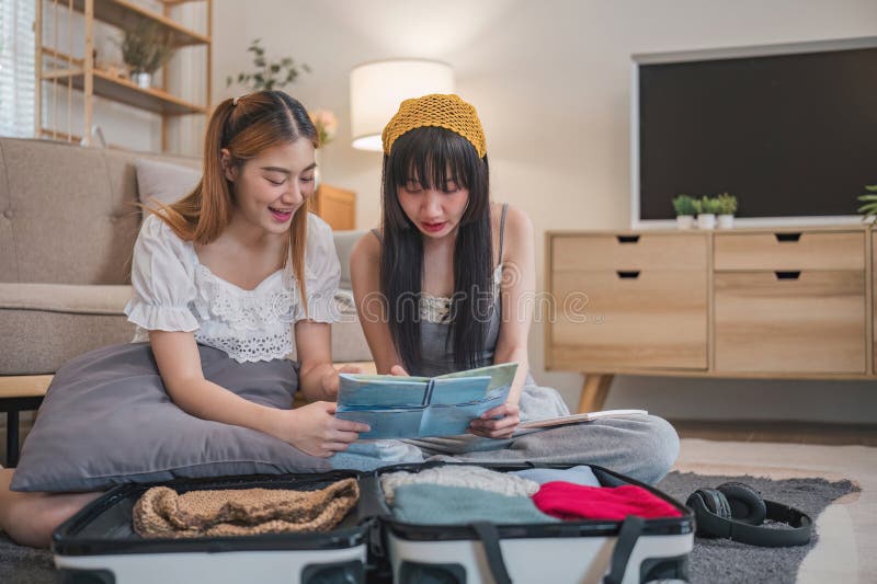 Two women are sitting on the floor looking at a map. She is planning to go on holiday. Two women are sitting on the floor looking at a map. She is planning to go on holiday..