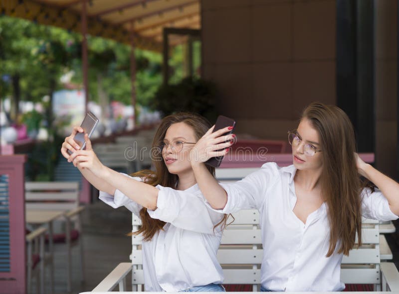Δύο γυναίκες που κάνουν ένα selfie καθμένος σε έναν θερινό καφέ Συνεδρίαση και φιλία Κοινωνική έννοια δικτύων στοκ φωτογραφίες Δύο γυναίκες που κάνουν ένα selfie καθμένος σε έναν θερινό καφέ Συνεδρίαση και φιλία Κοινωνική έννοια δικτύων στοκ φωτογραφίες