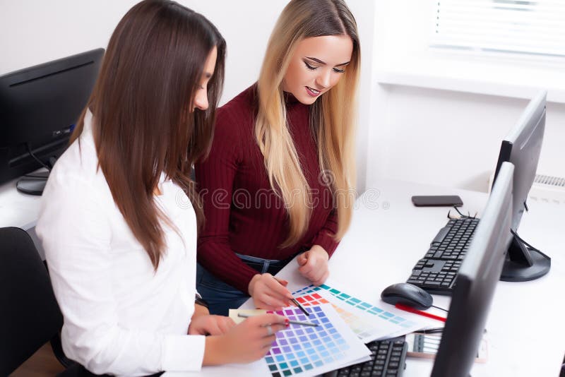 Two female colleagues in office working together. Two female colleagues in office working together.