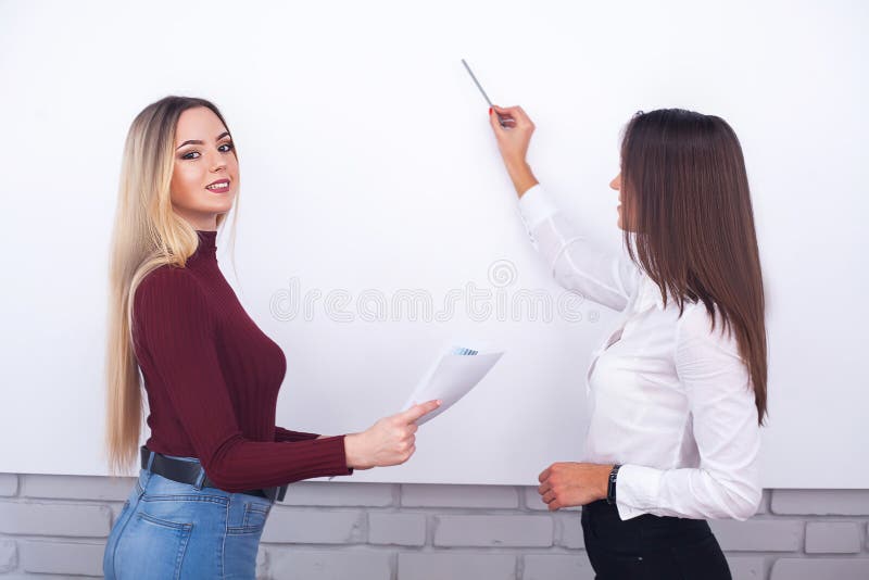 Two female colleagues in office working together. Two female colleagues in office working together.