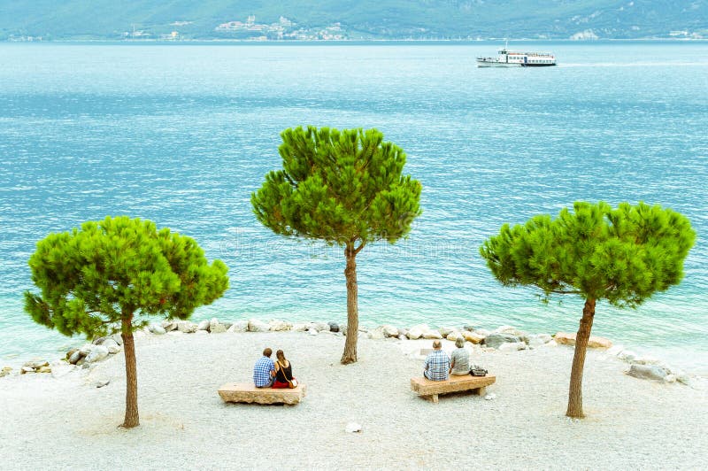 Δύο ζεύγη στην παραλία Limone sul Garda, Ιταλία στοκ εικόνα με δικαίωμα ελεύθερης χρήσης Δύο ζεύγη στην παραλία Limone sul Garda, Ιταλία στοκ εικόνα με δικαίωμα ελεύθερης χρήσης
